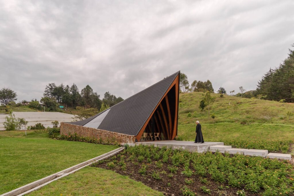Proyecto arquitectónico Vicaría en entorno montañoso - diseño contemporáneo integrado al paisaje natural con techos inclinados y materiales locales
